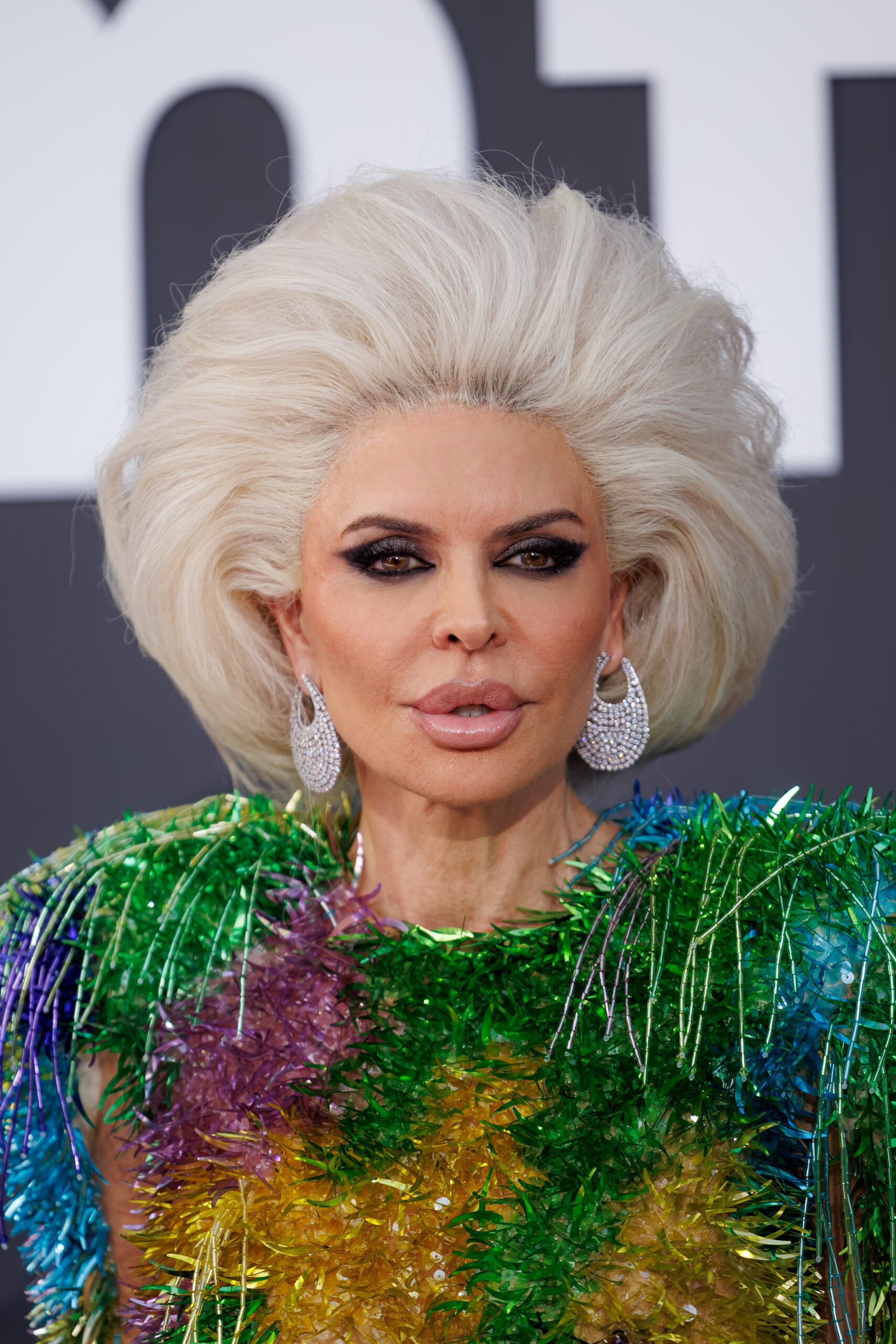 Lisa Rinna pouting wearing a blonde wig and large earrings