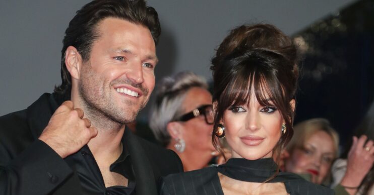 Mark Wright smiling beside Michelle keegan with a serious expression