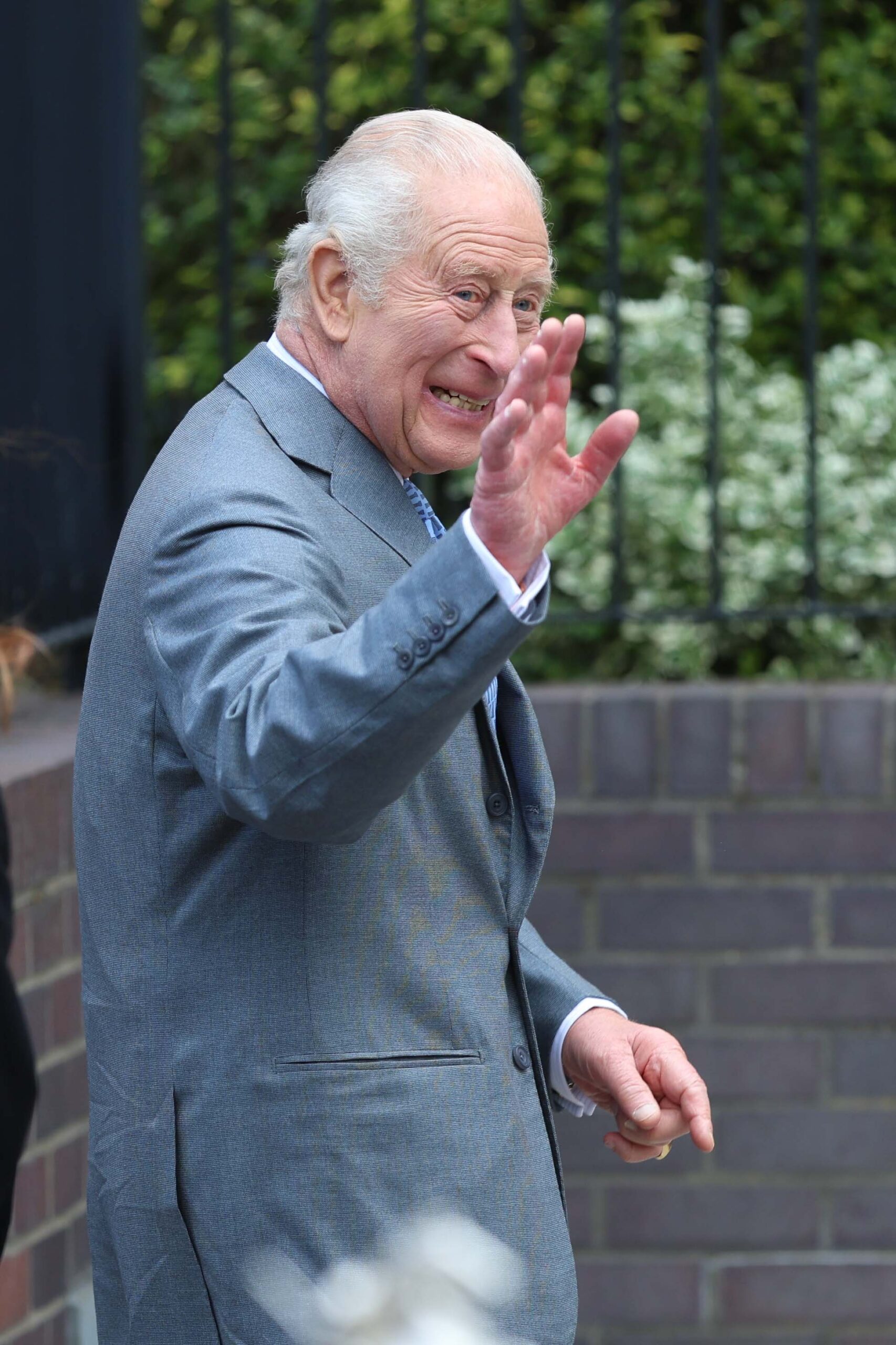 King Charles waving in grey suit