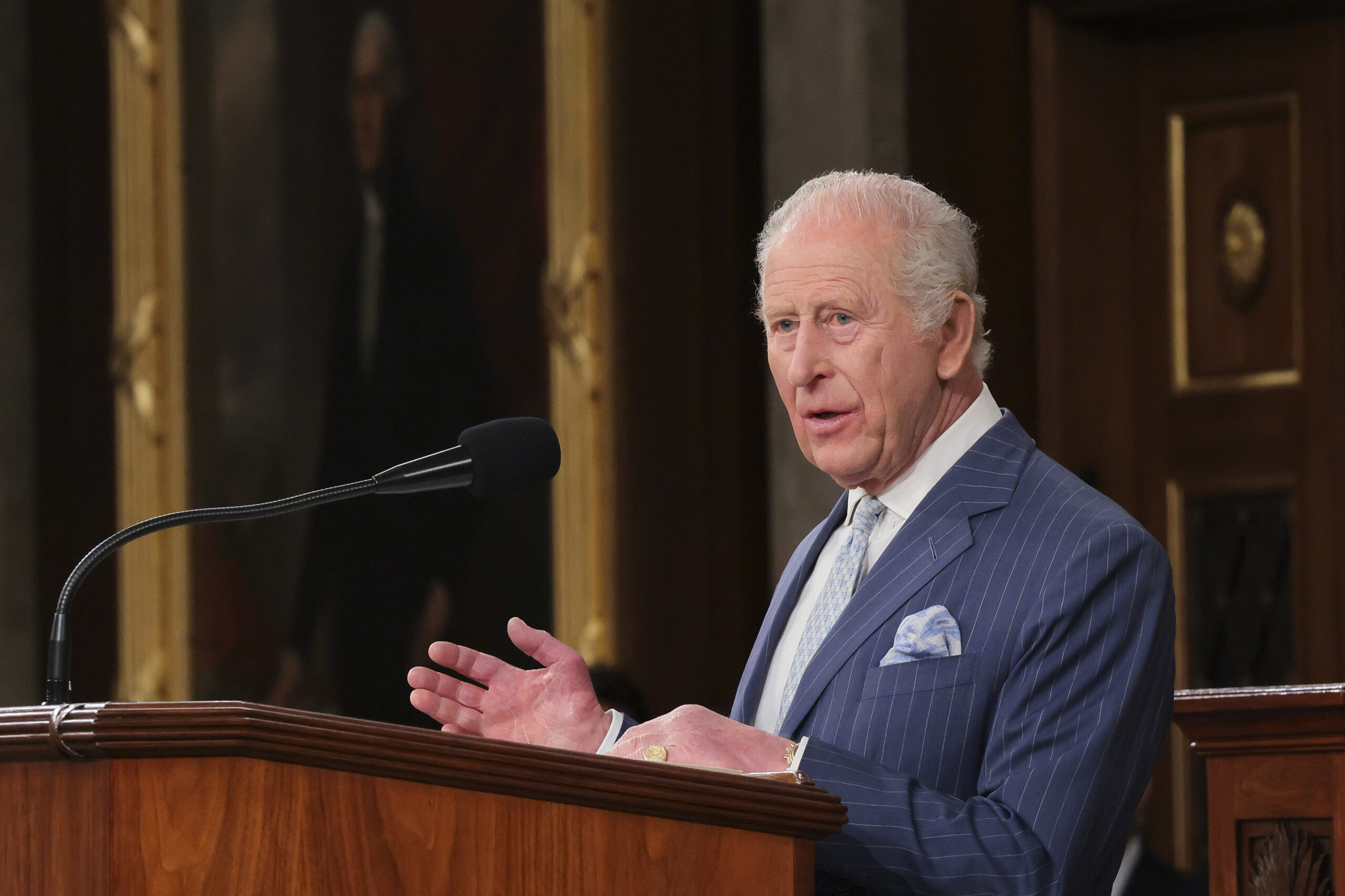 King Charles talking into a mic at a podium