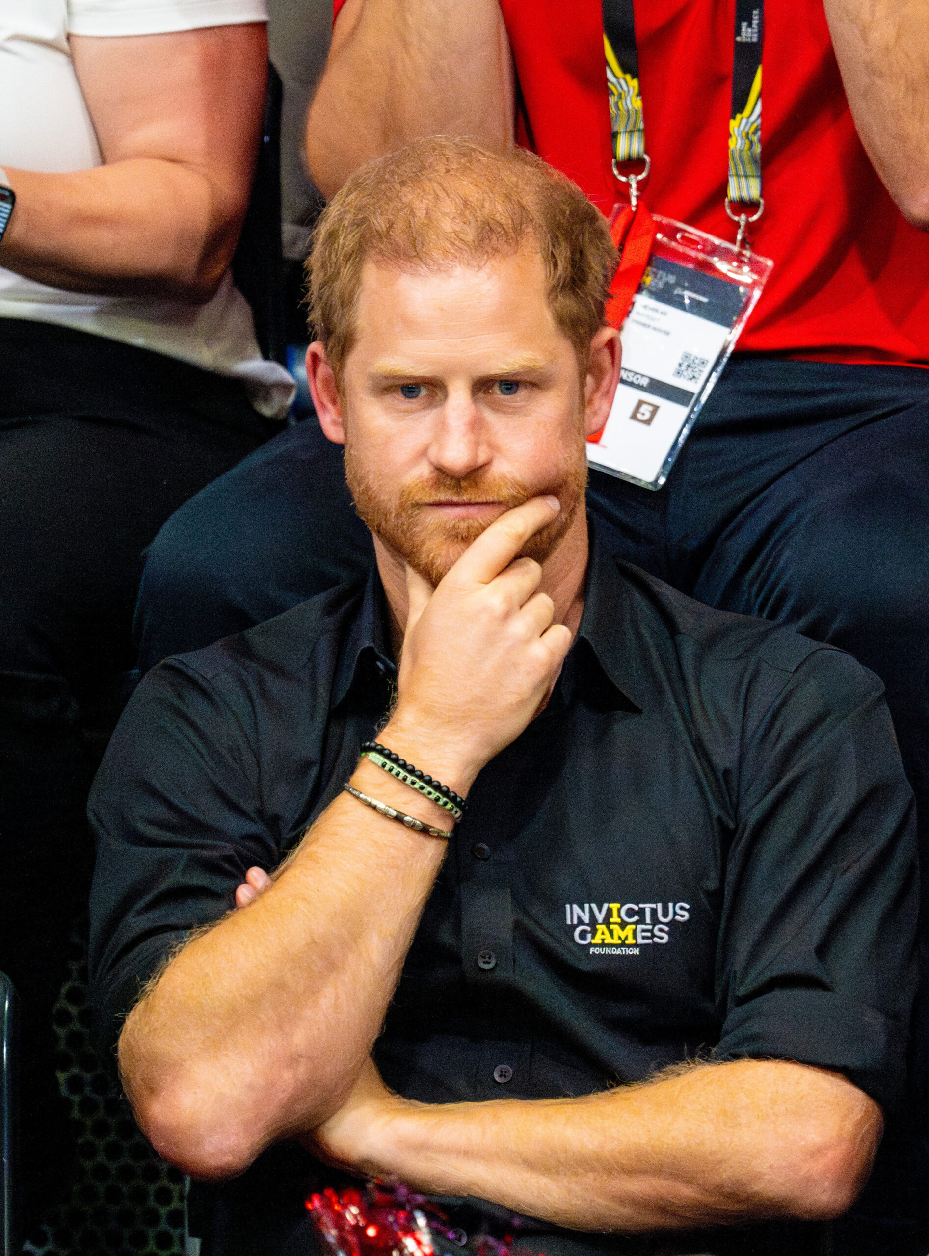 Prince Harry frowning holding his chin