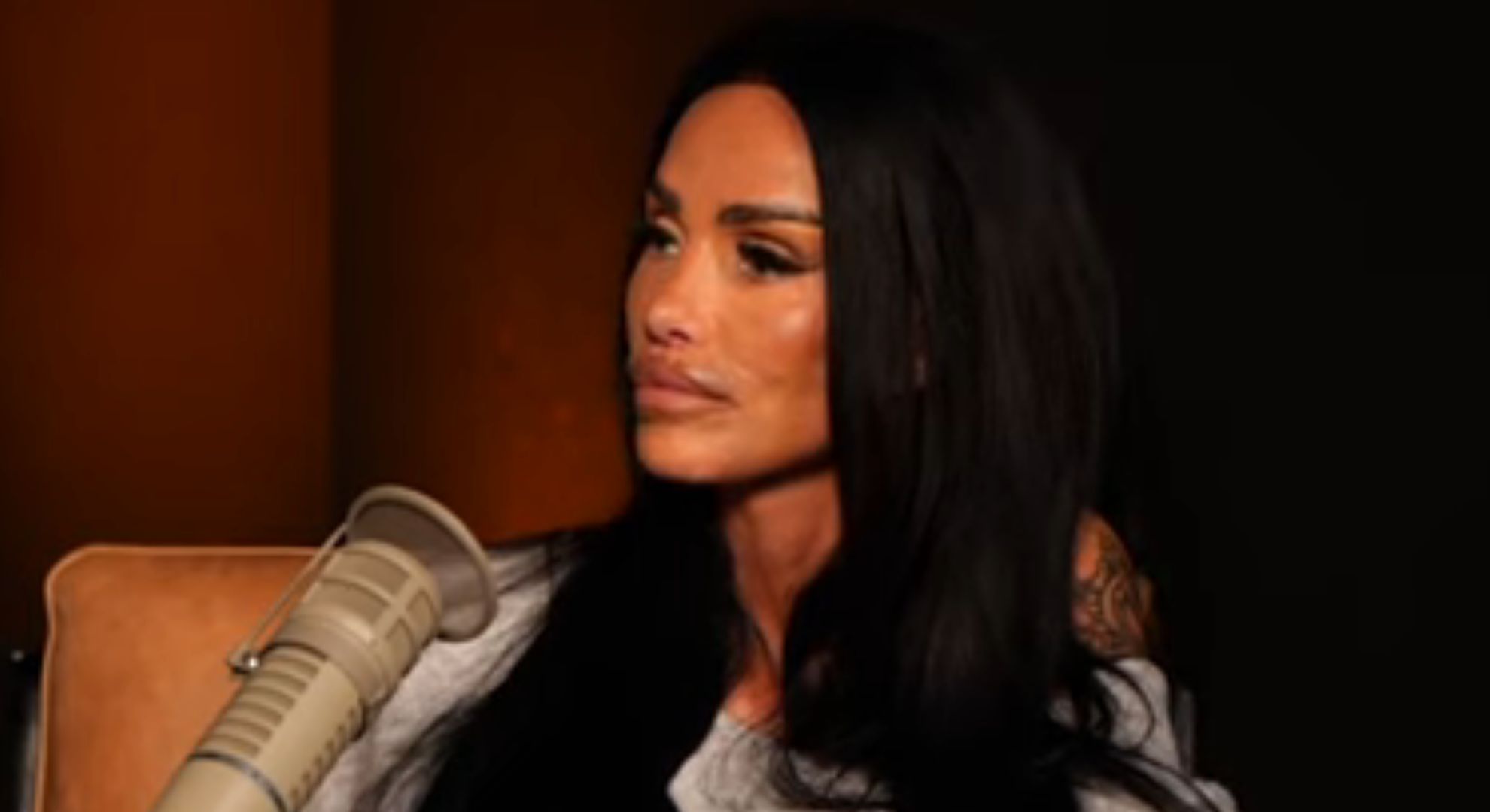 Katie Price talking into a microphone during a podcast interview