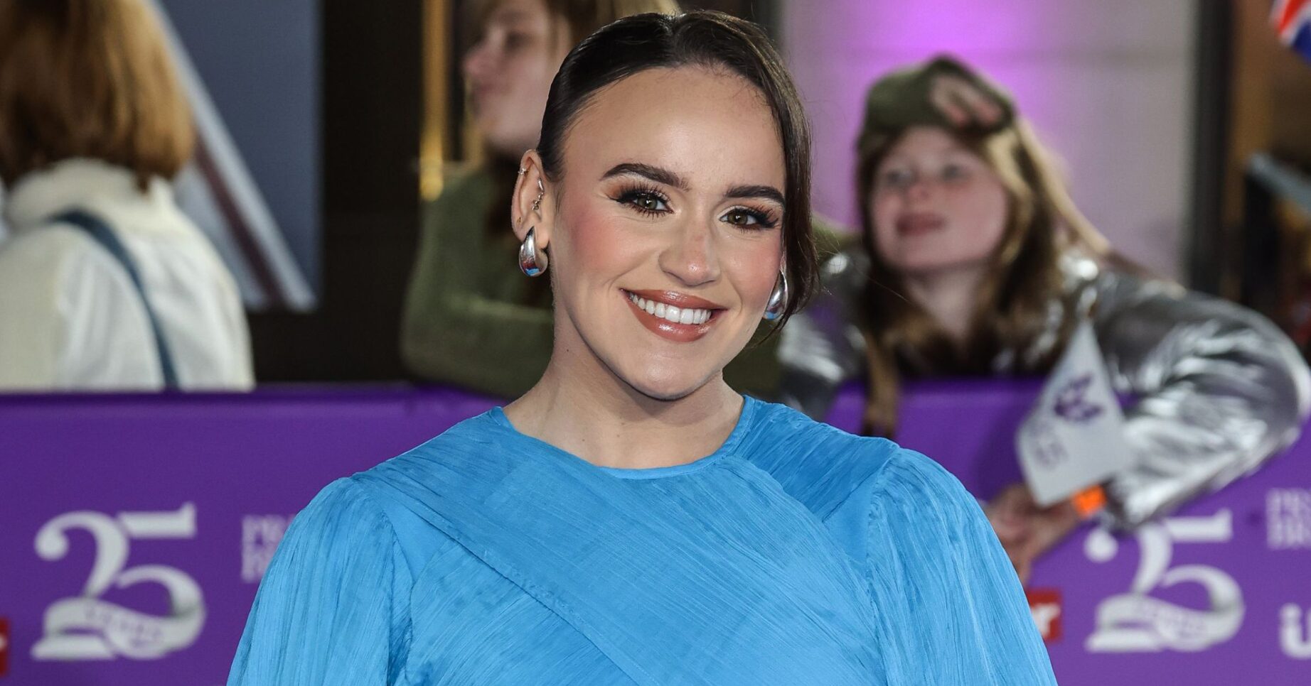 Ellie Leach smiling wearing blue