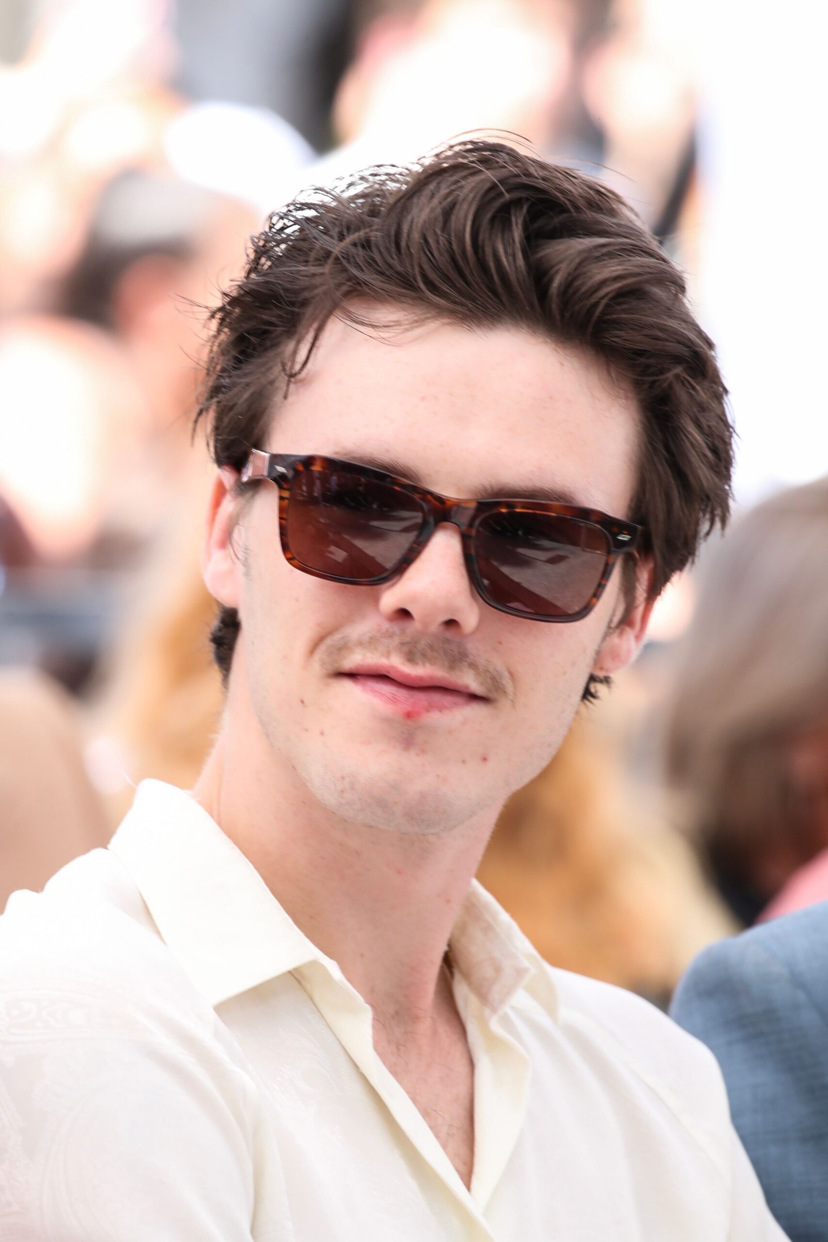 Cruz Beckham smiling with sunglasses on