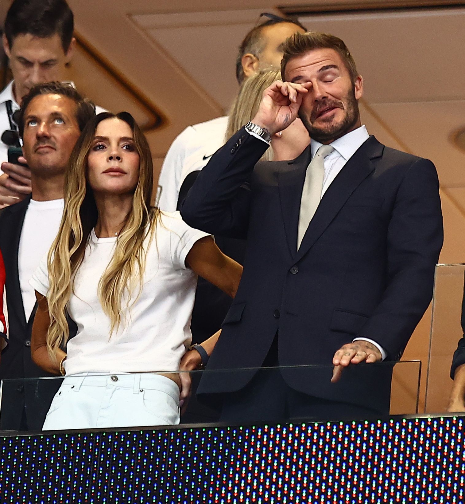 Victoria Beckham frowning as David Beckham wipes his eyes whilst watching England in the World Cup semi-final