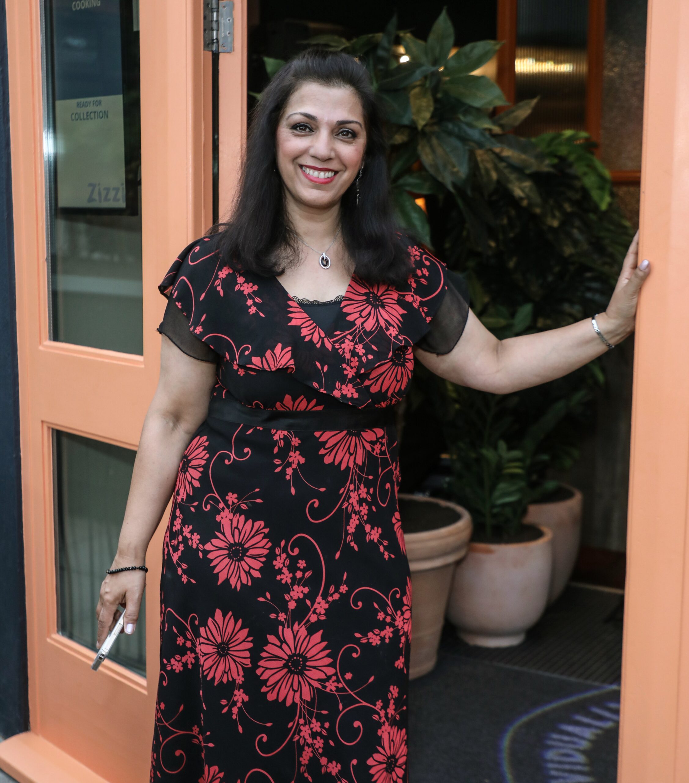 Parveen Ashraf in black and red floral dress