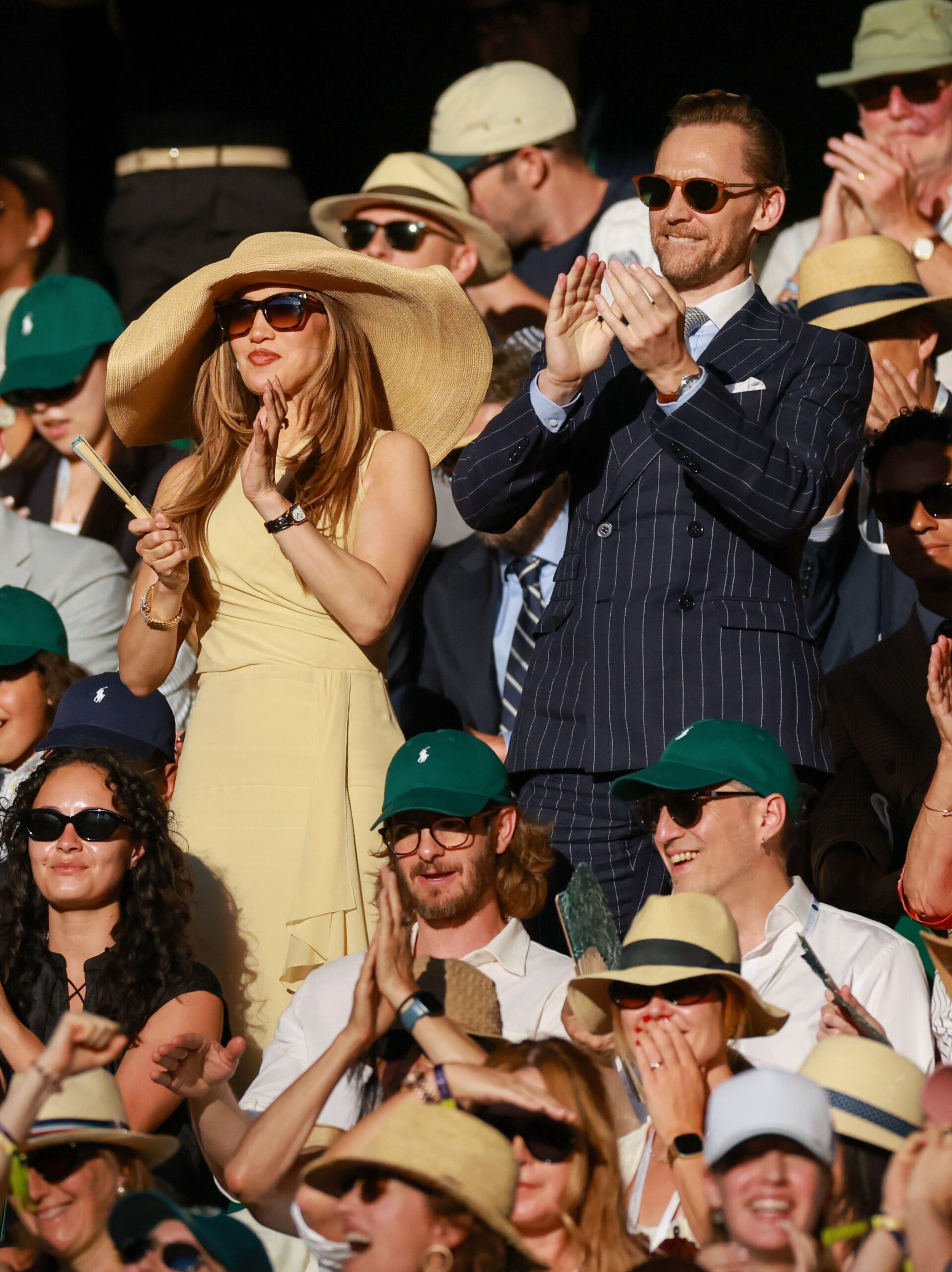 Wimbledon Tennis Championships, Day 14, Jennifer Lopez stood beside Tom Hiddleston during applause, Jennifer is wearing a beige dress and a giant hat.