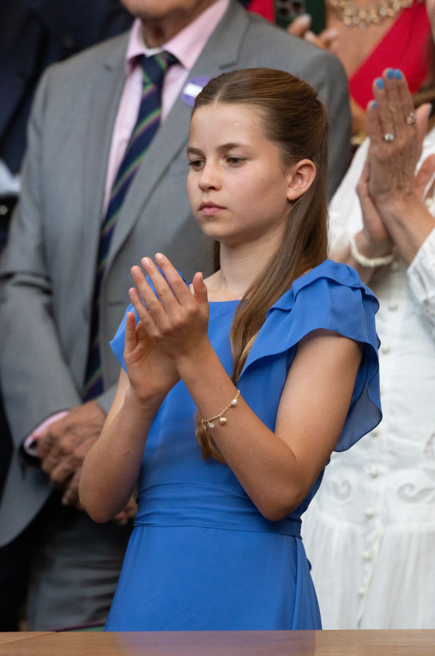 Princess Charlotte wearing a blue dress and a charm bracelet at Wimbledon