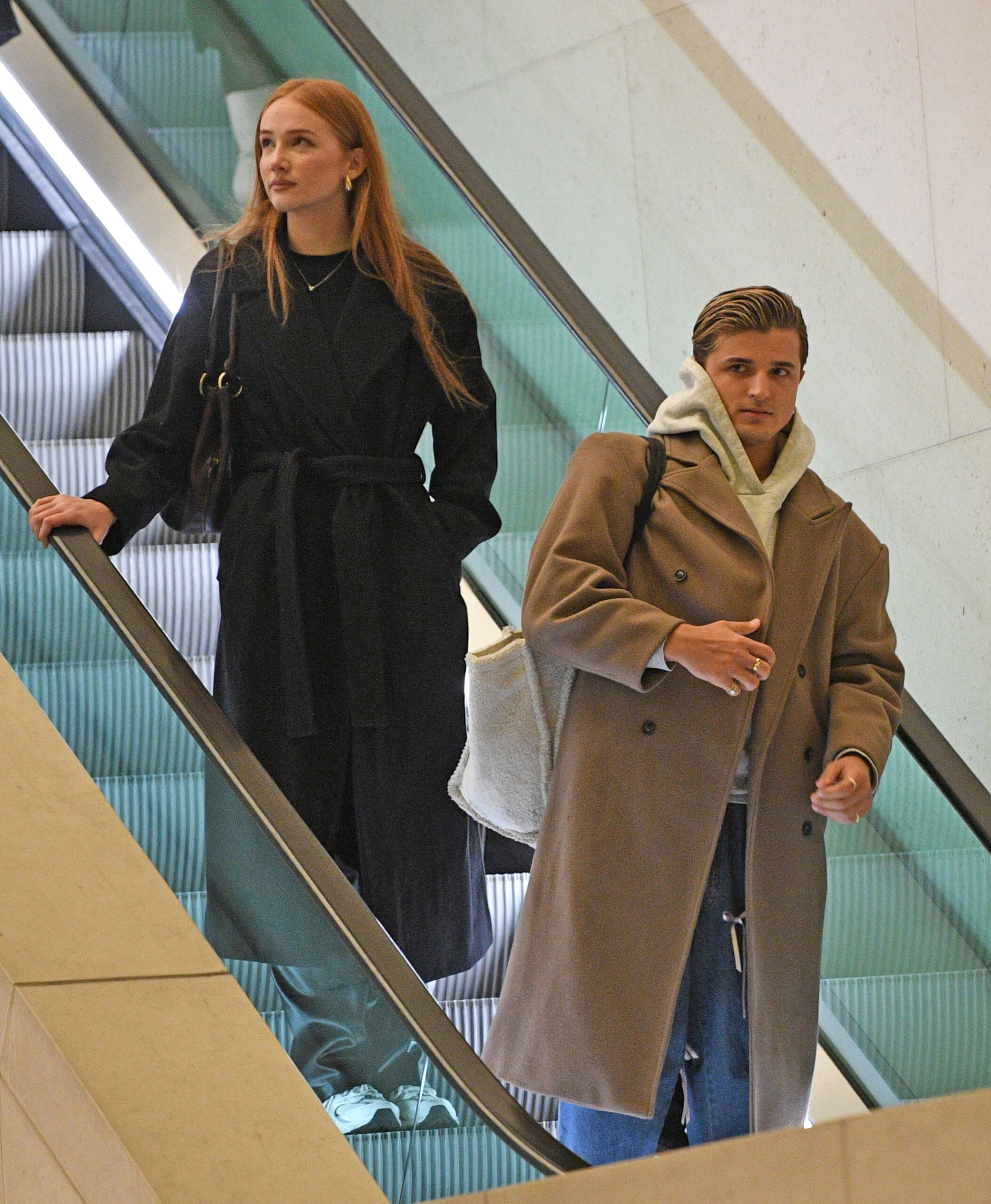 Nikita Kuzmin and Lauren Jaine on an escalator 
