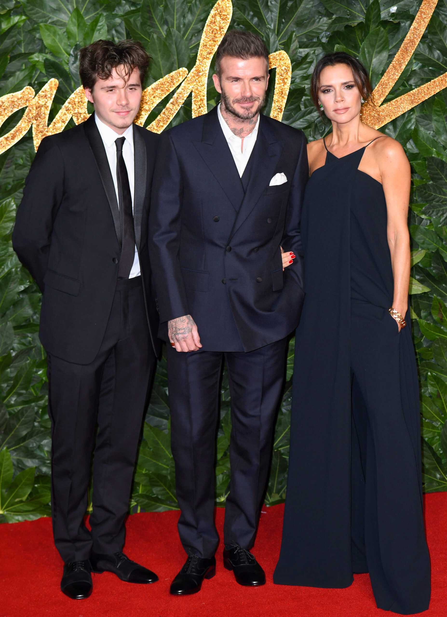 Brooklyn Beckham with his parents at event