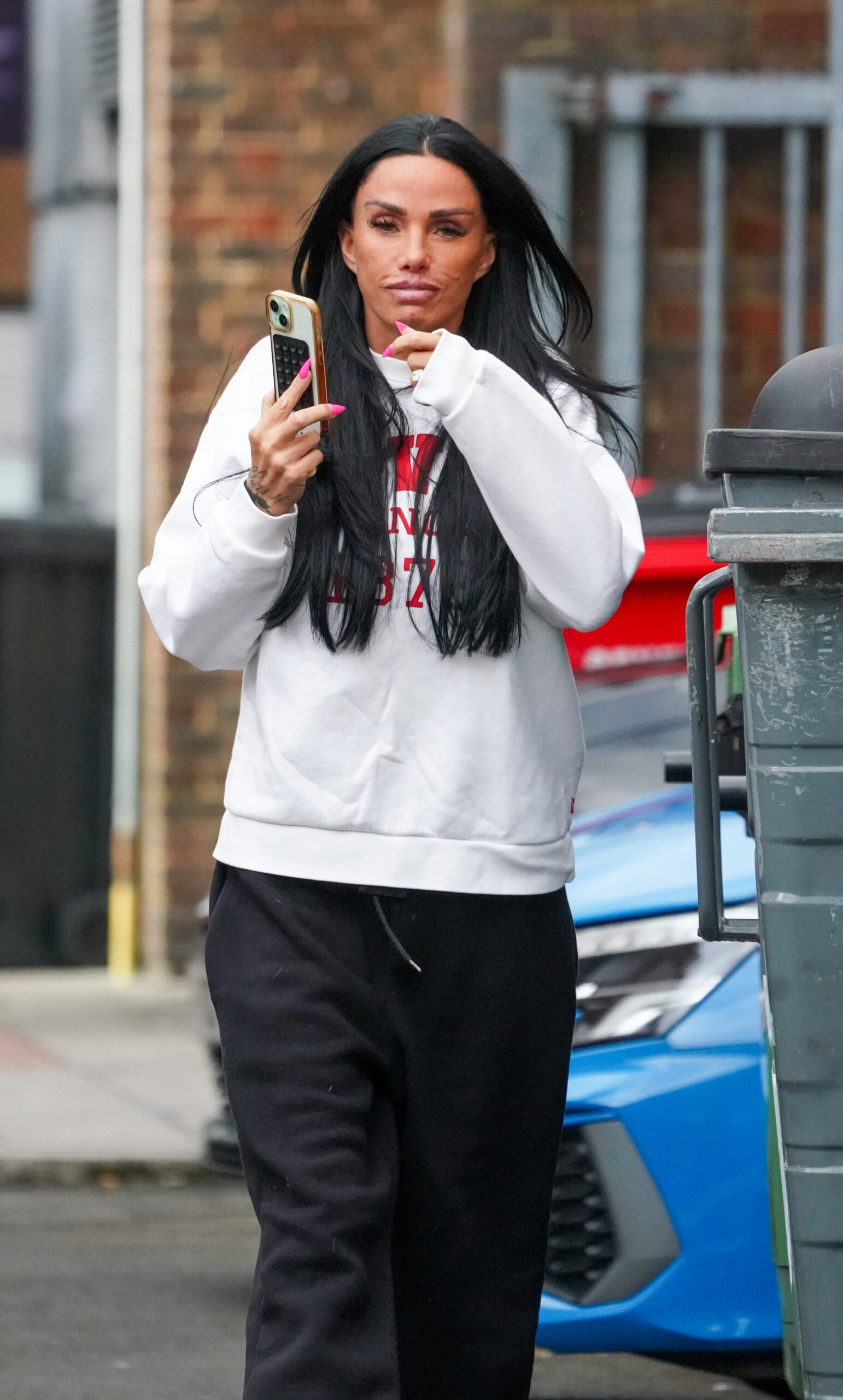 Katie Price holding her phone