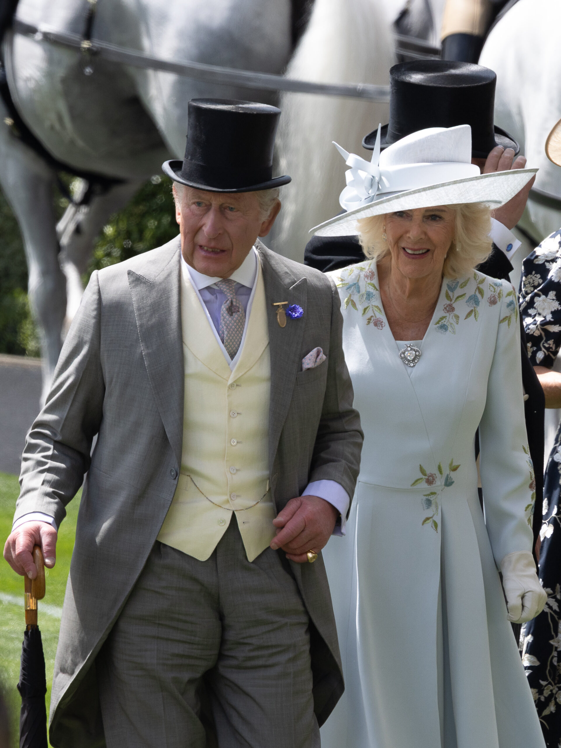 King Charles and Queen Camilla hold onto each other