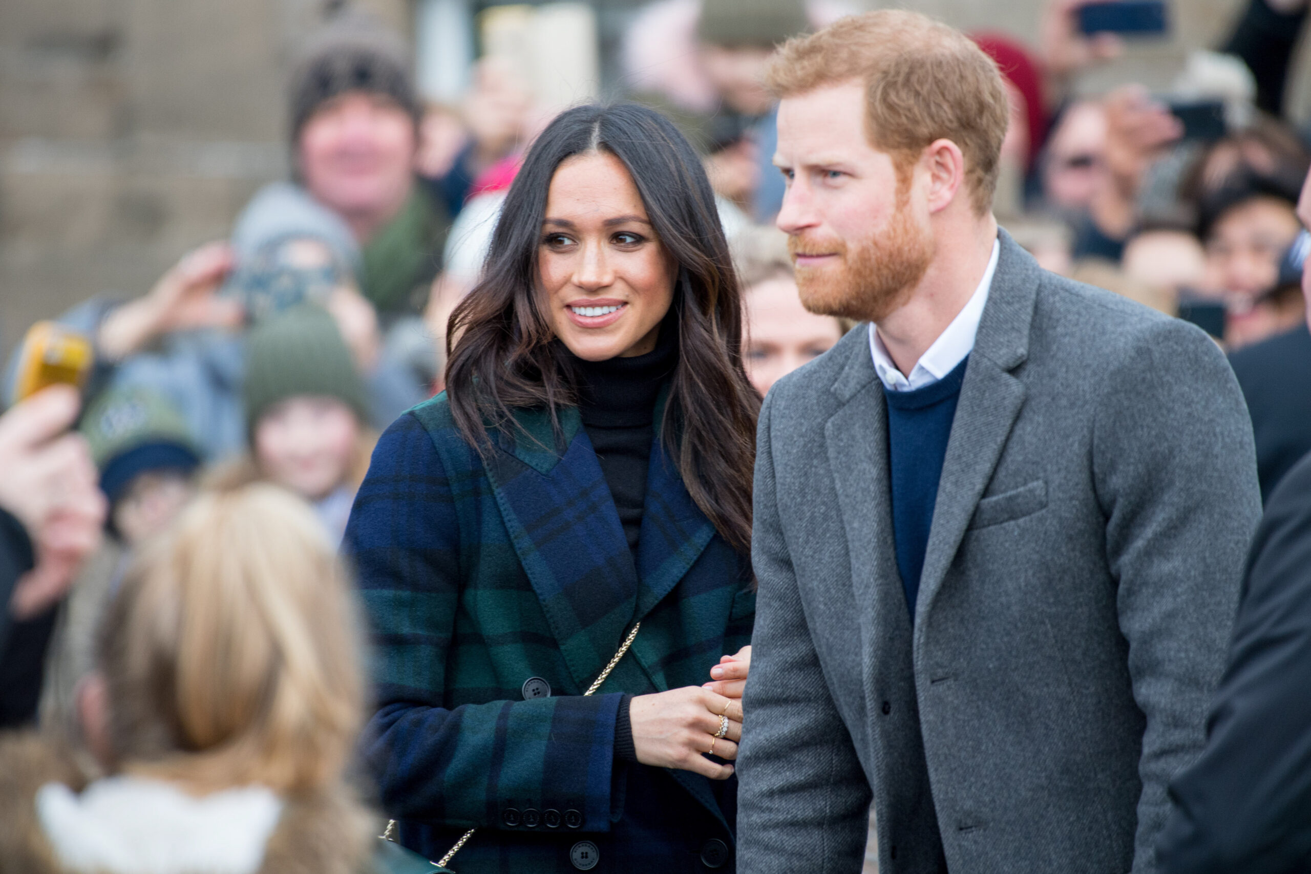 Meghan looks happy as she cosies up to Prince Harry