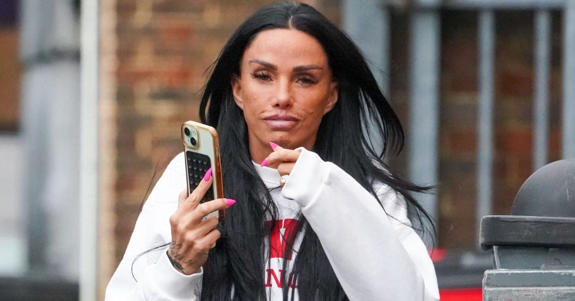Katie Price holding her phone