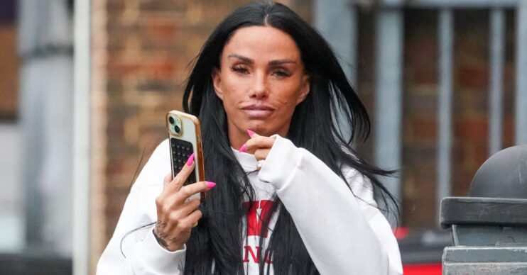 Katie Price holding her phone