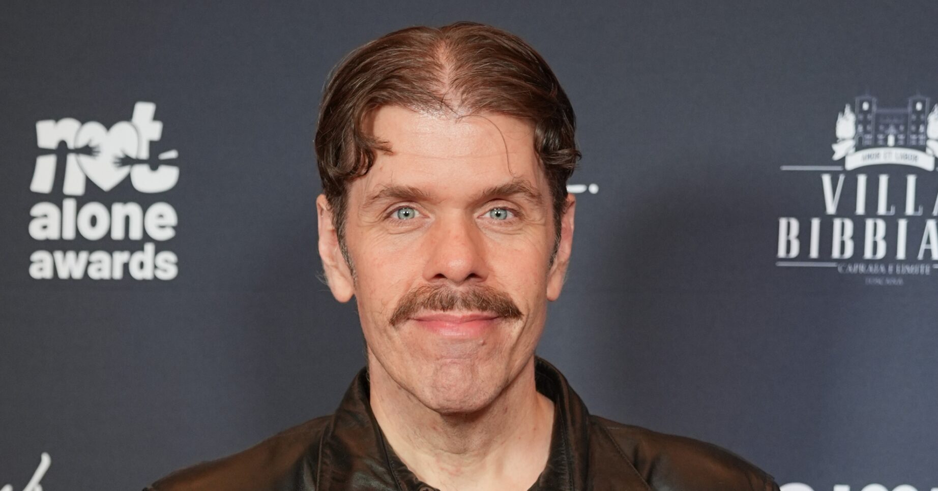 Perez Hilton smiling at event
