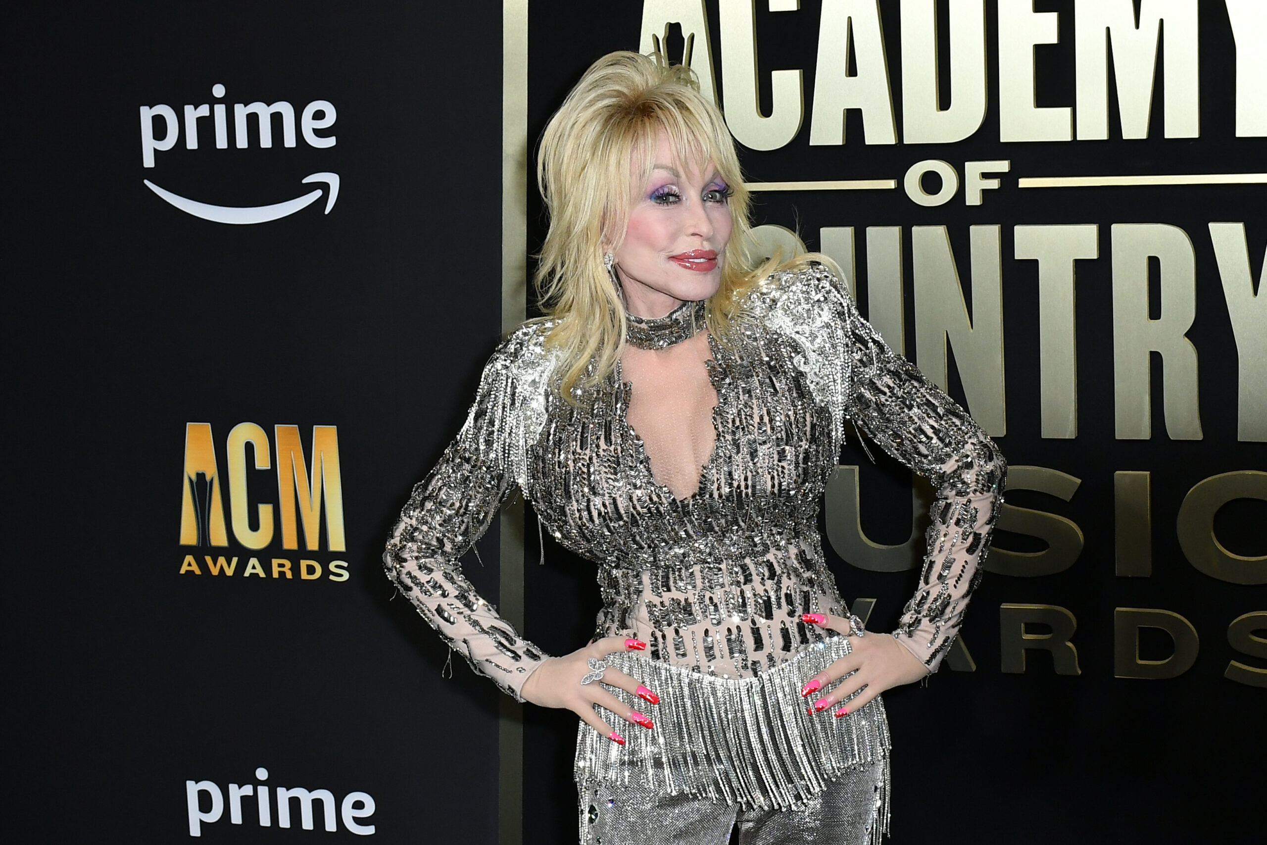Dolly Parton puts her hands on her hips