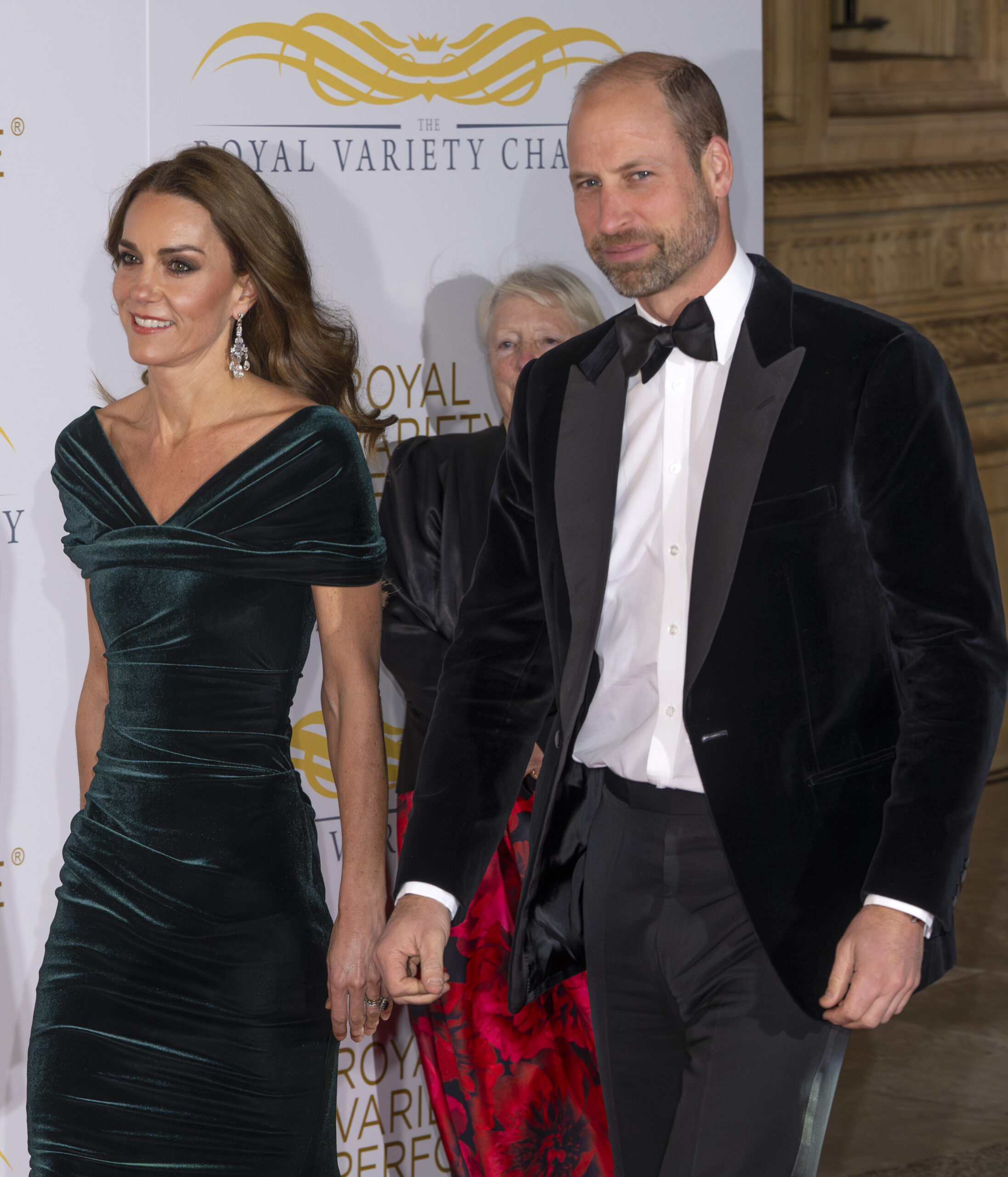 Prince William walks alongside his wife Princess Kate who wears an elegant green dress