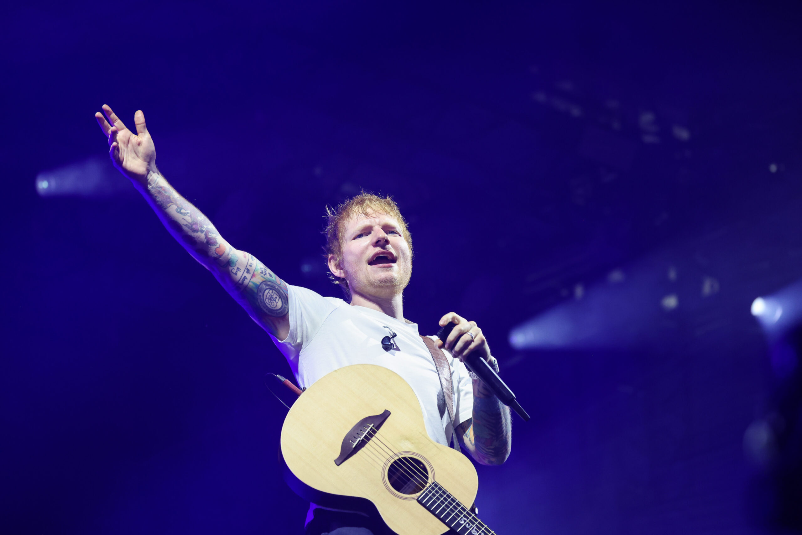 Ed Sheeran plays guitar at concert