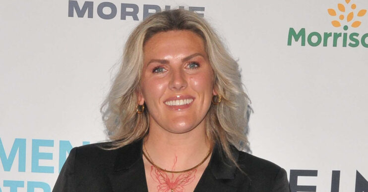 Millie Bright smiling in black blazer