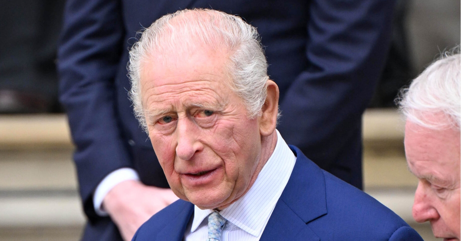 King Charles looking serious in blue suit