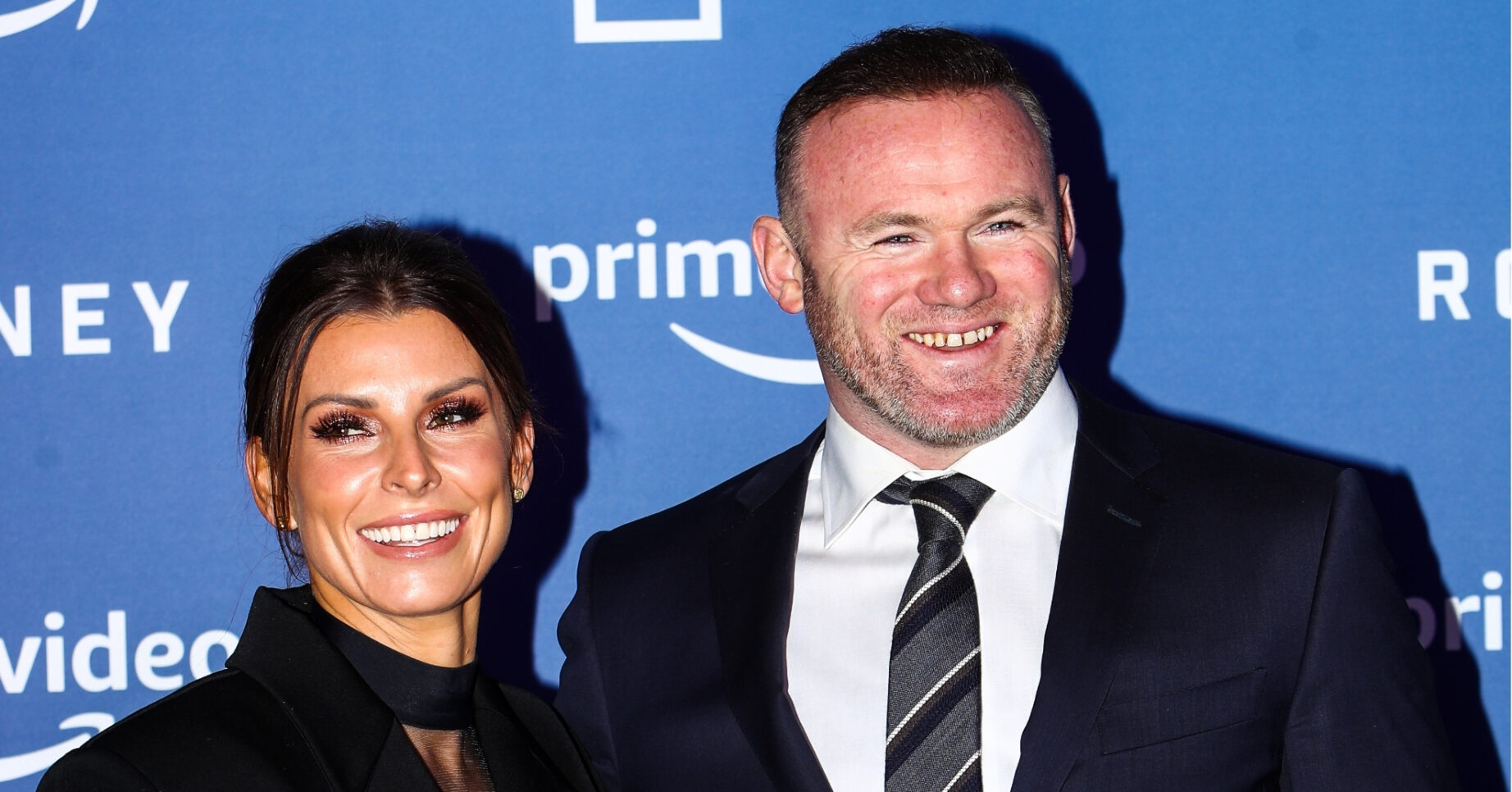 Coleen and Wayne Rooney smiling at event