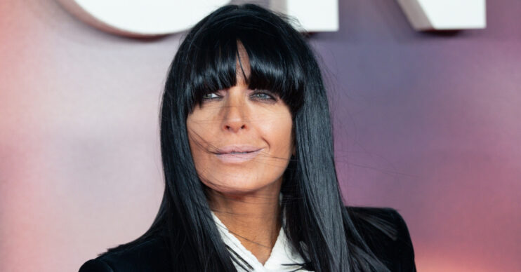 Claudia Winkleman smiling in black suit at event