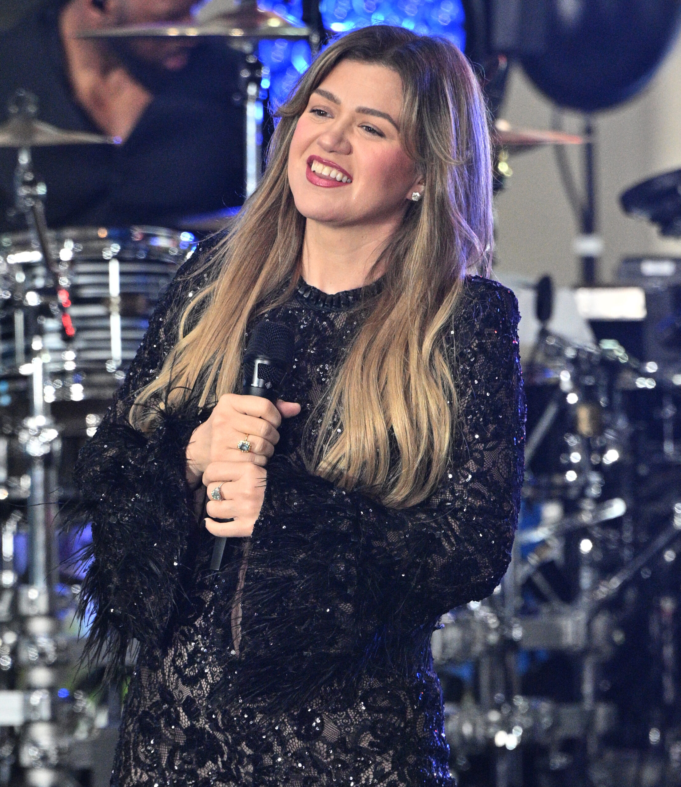 Kelly Clarkson holds a microphone