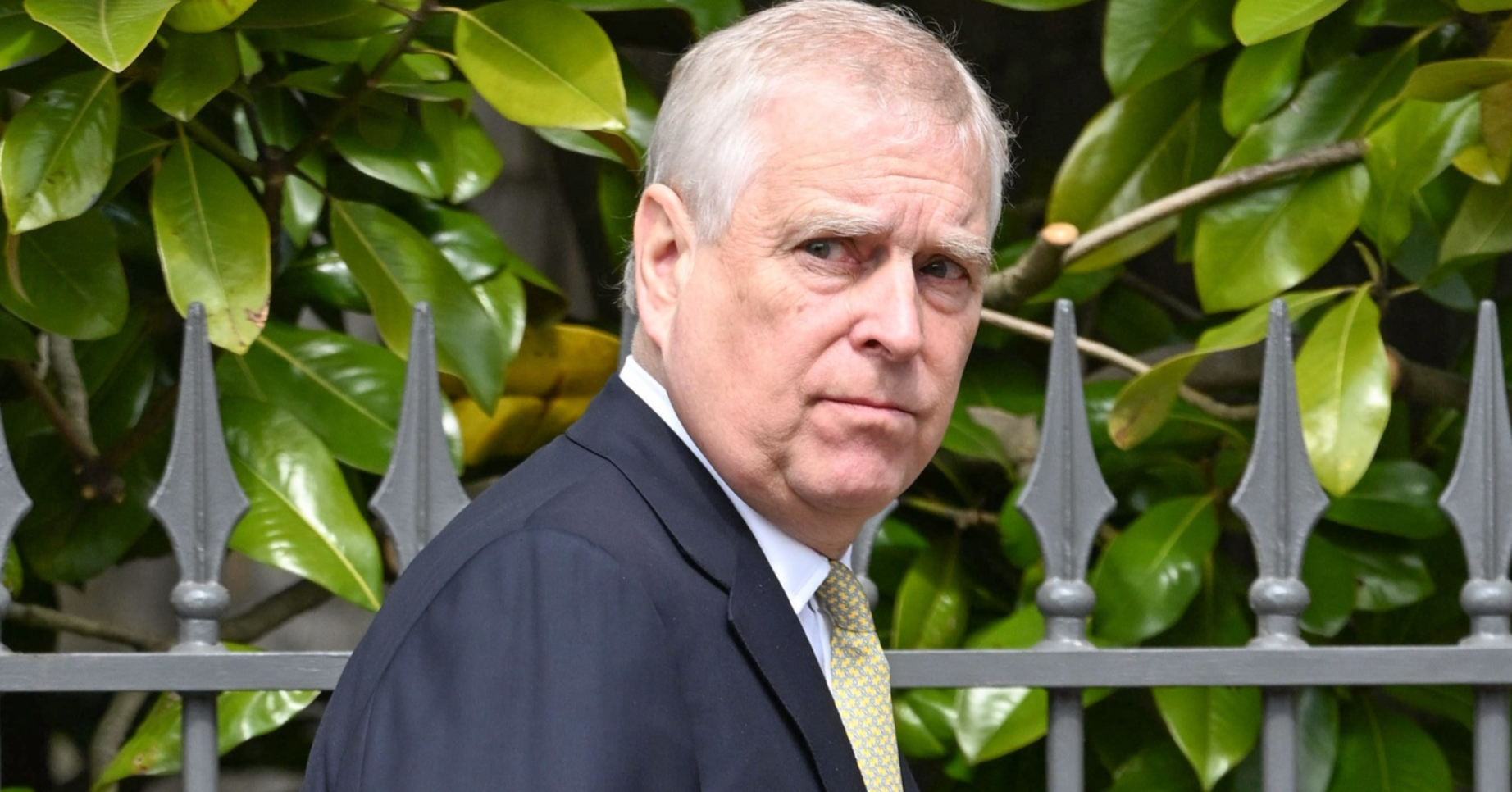 Andrew Mountbatten-Windsor looks over his shoulder
