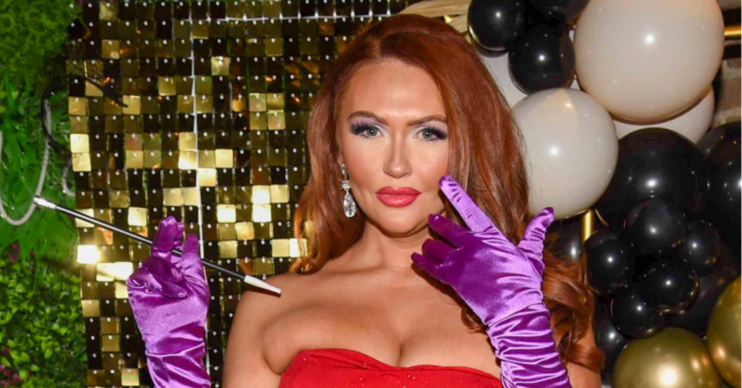 Charlotte Dawson poses in a red dress with gloves