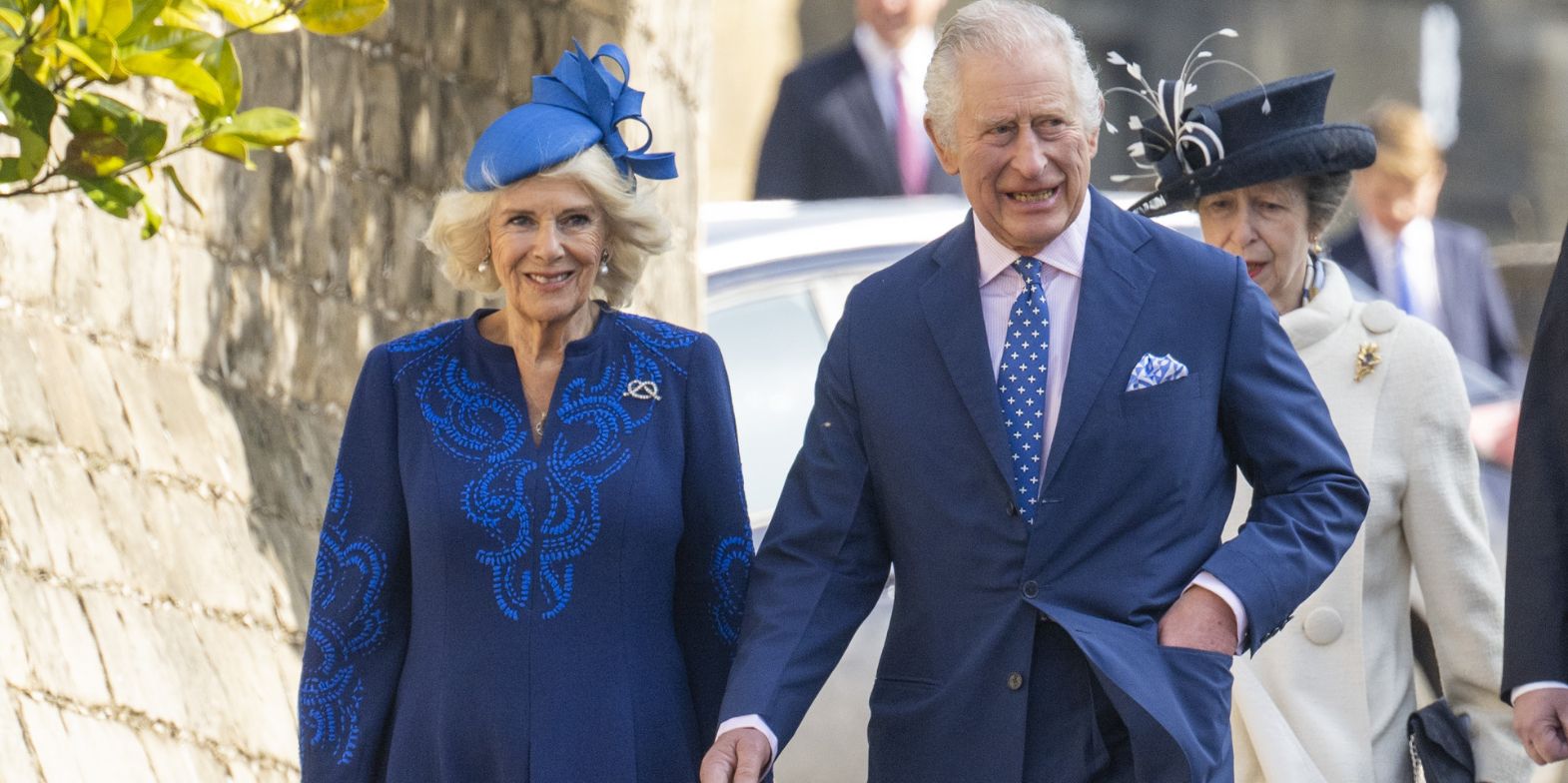 Queen Consort Camilla and King Charles holding hands smiling