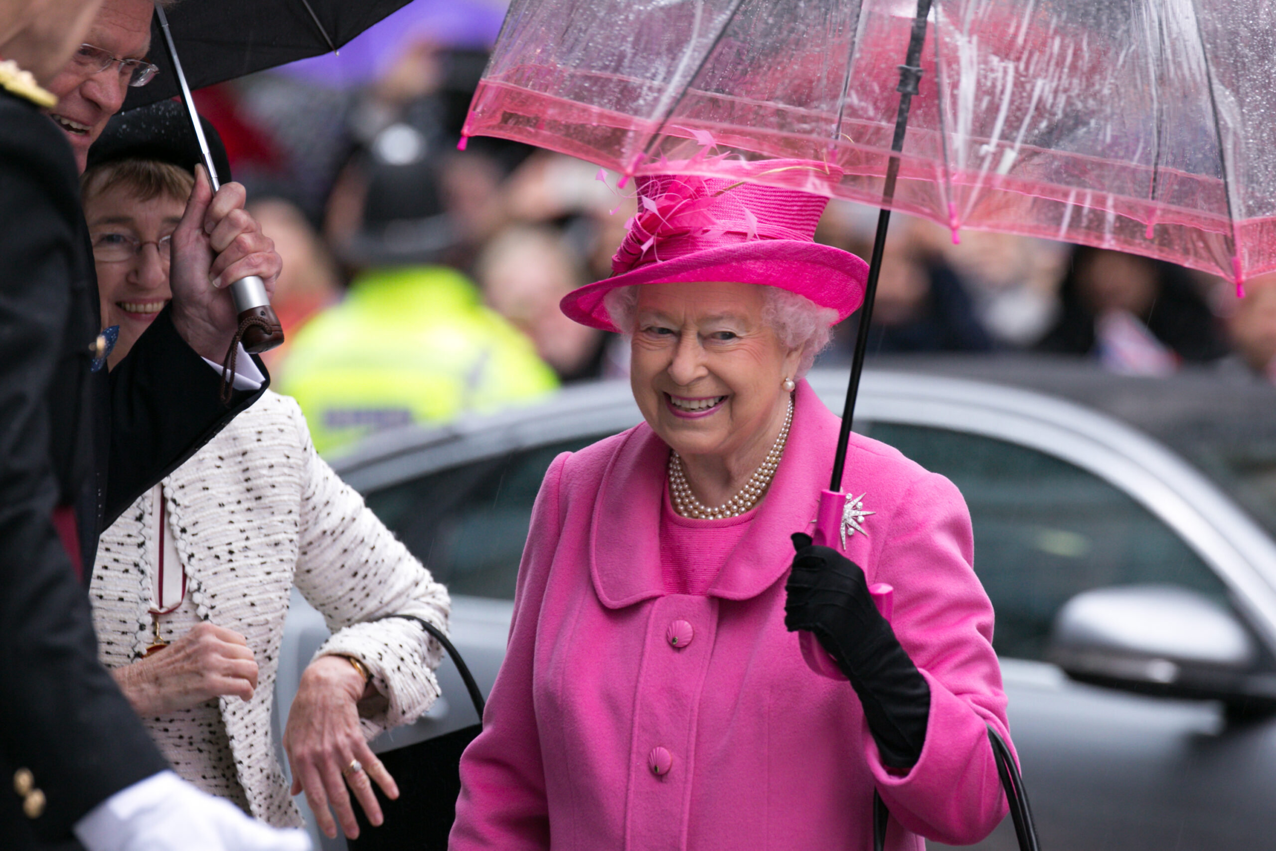 Queen Elizabeth II smiling wearing pink
