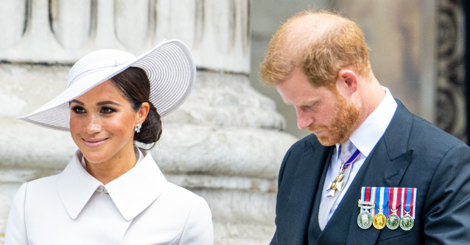 Meghan Markle smiling as Prince Harry looks down
